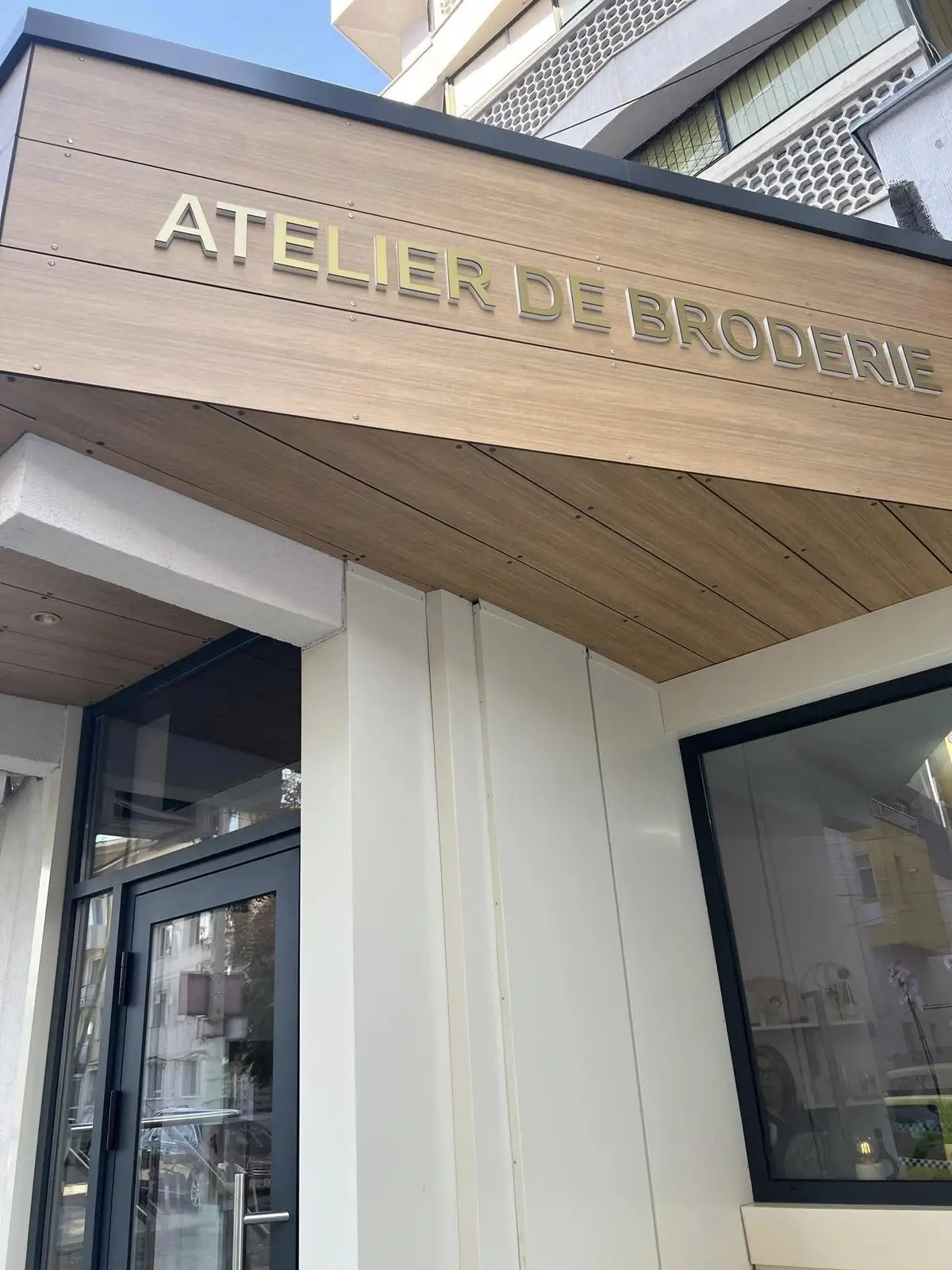 Firma Atelier de broderie Murra pe clădirea magazinului Luceafărul din Bacău